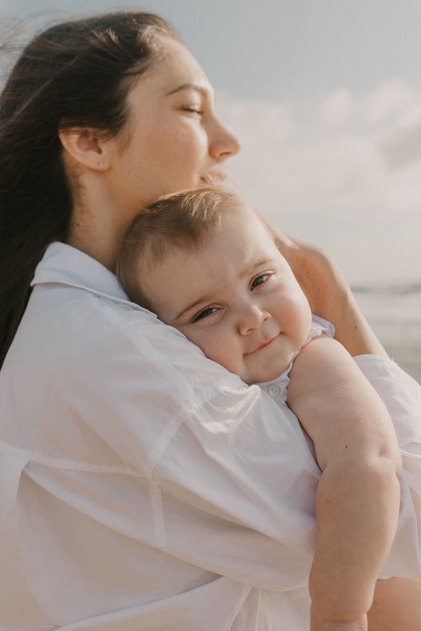 A mom hugging her baby while travelling on the road