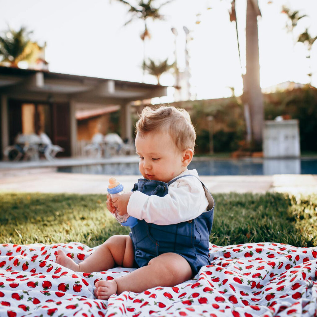 Toddler playing on a picnic mat at the garden